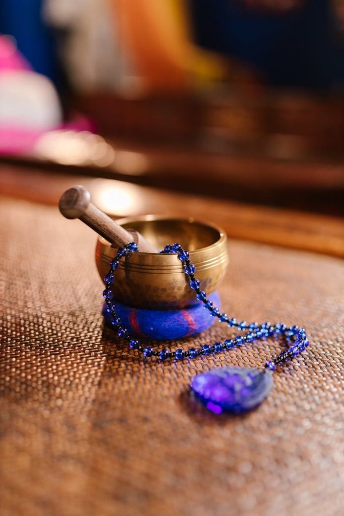 Photograph of a singing bowl with purple prayer beads